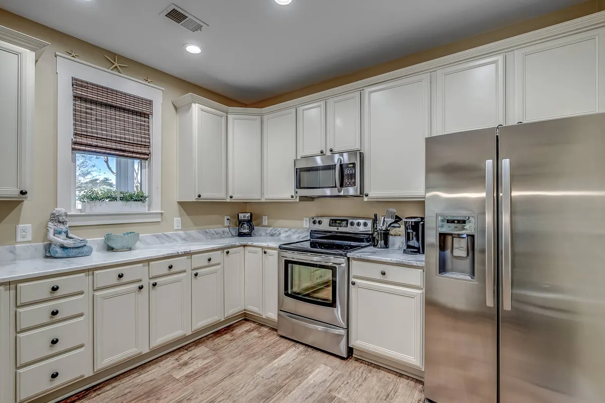 A spacious, modern kitchen with gleaming stainless steel appliances, a marble countertop, and light cabinetry. The space is designed for shared meals and gatherings, making it an inviting hub for guests to plan their day's explorations and enjoy meals together.