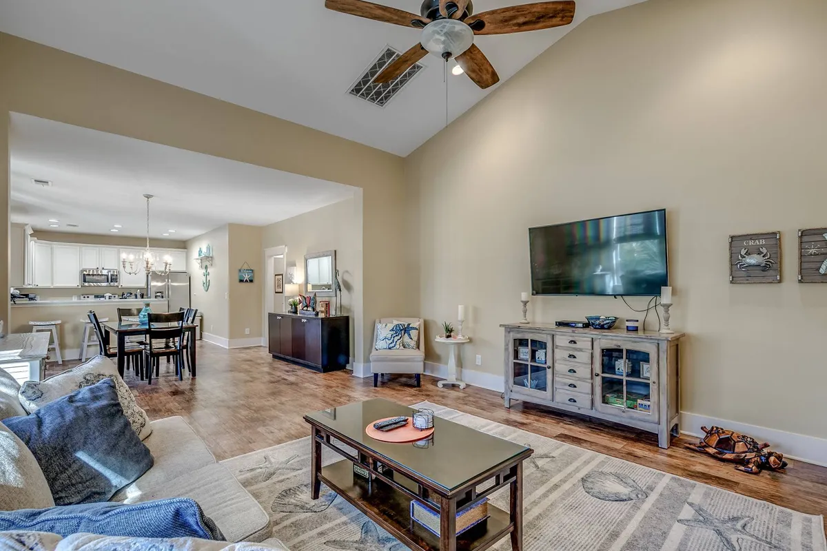 This image presents a comfortable living area featuring a sofa, coffee table, television, and a spacious dining area. The setting is designed for entertaining, unwinding, and spending quality time with others after active pursuits.